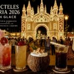 Cócteles de Feria 2026 de Glace frente a la portada iluminada de la Feria de Córdoba con algodón de azúcar, rebujito y alta coctelería andaluza.